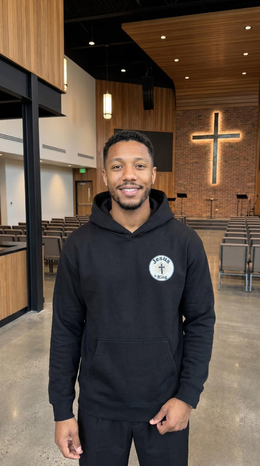Male model wearing Jesus Is King Christian hoodie by Daniel Haus Goods, modern Christian clothing for intentional living.