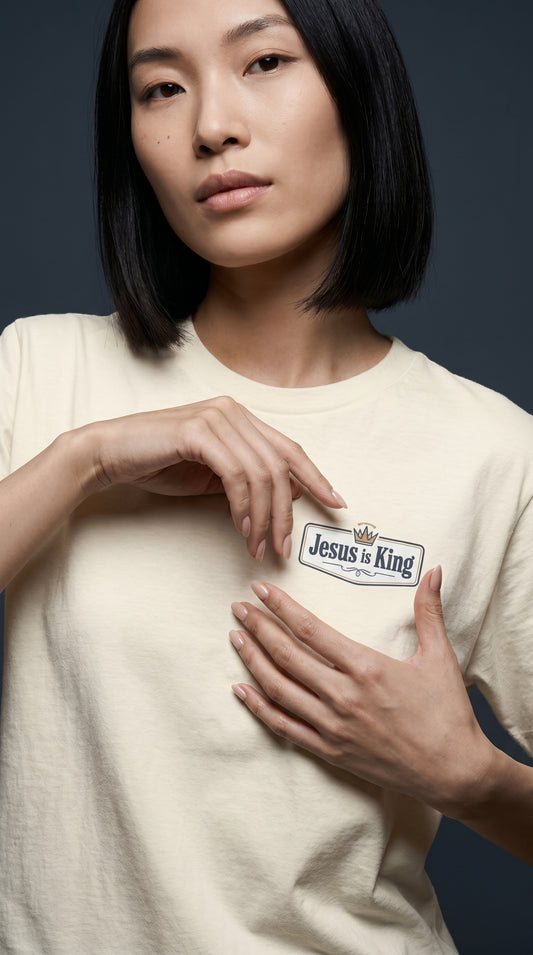 Female model wearing Jesus Is King Christian T-shirt by Daniel Haus Goods, modern faith-inspired everyday clothing.